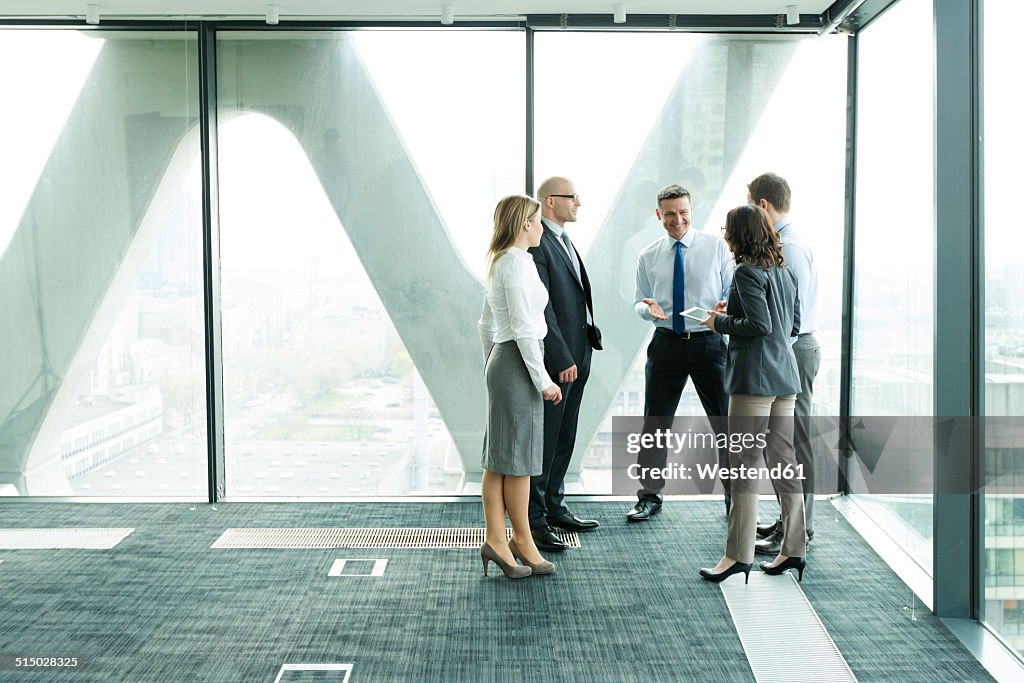 Businesspeople in office with woman using digital tablet