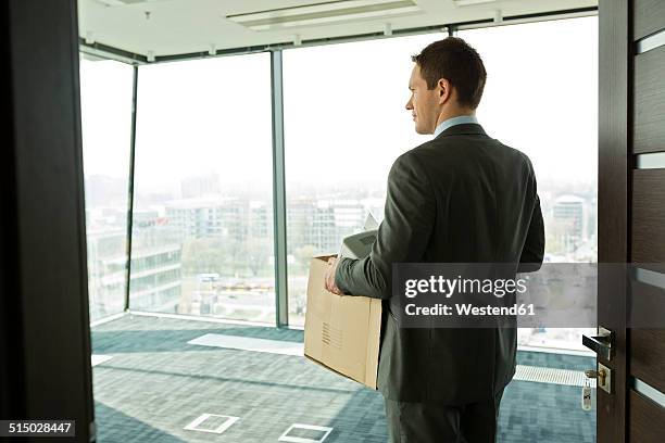 businessman carrying cardboard box in office - city on the move stock pictures, royalty-free photos & images