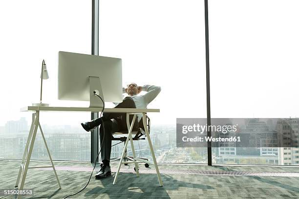 businessman leaning back in new office - makeshift office stock pictures, royalty-free photos & images