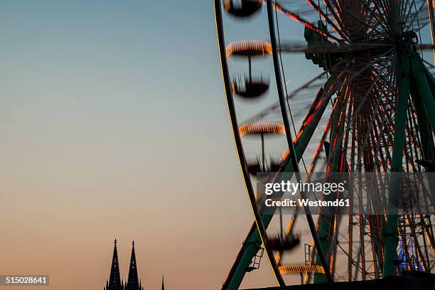 germany, north rhine-westphalia, cologne, cologne cathedral and part of big wheel at sunset - colonia renania fotografías e imágenes de stock