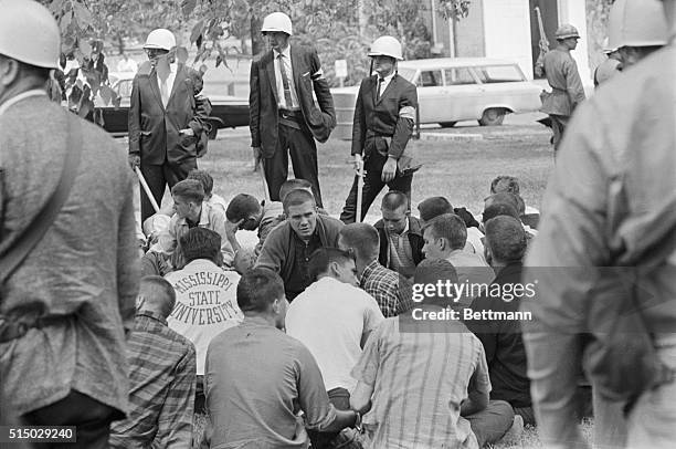 Students, arrested for alleged participation in riots at Ole Miss, sit on the ground surrounded by US marshals and FBI agents after the September 30,...