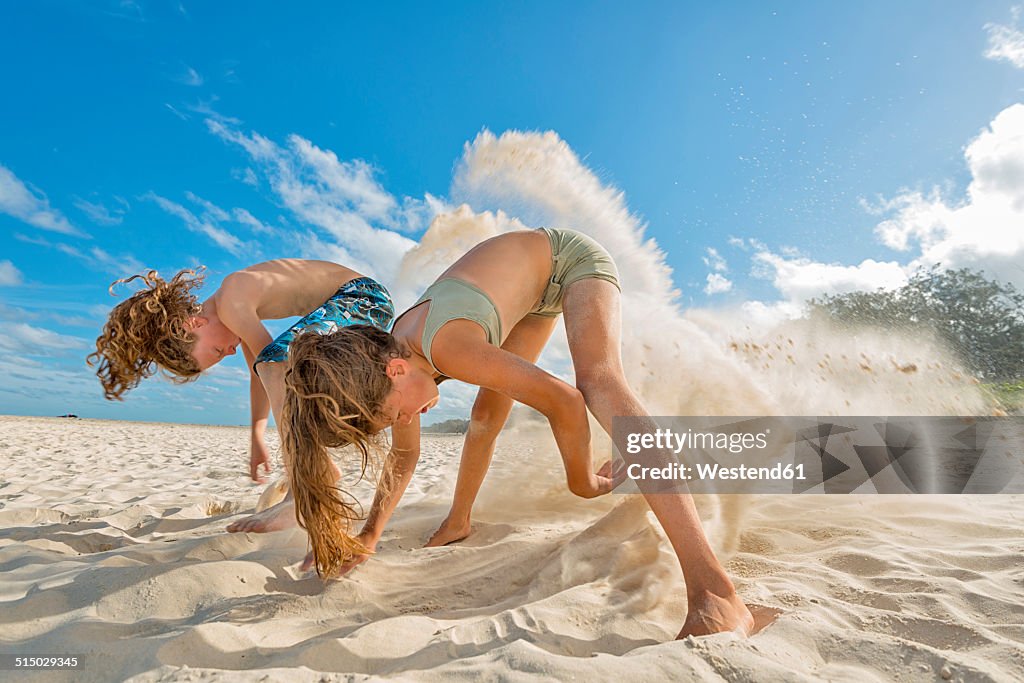 Australia, New South Wales, Pottsville, boy and girl digging in sand on beach