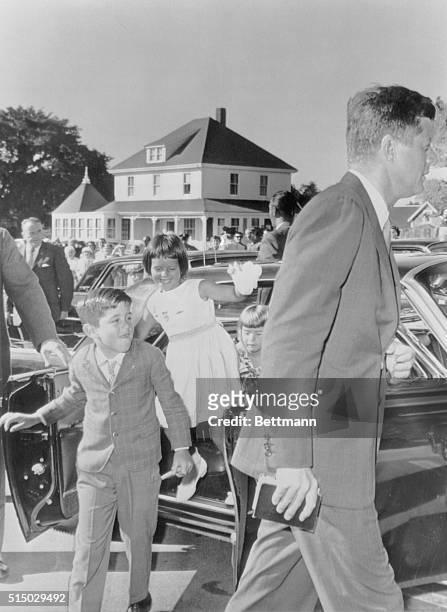 President John F. Kennedy arrives for a 9:00 A.M. Mass at St. Francis Xavier Catholic Church in Hyannis. Following their uncle to the service are...