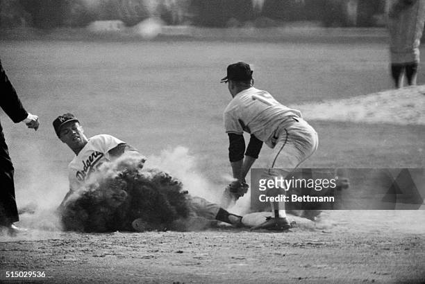 Speedy Maury Wills of the Los Angeles Dodgers, is shown in this exciting baseball action, stealing his 104th base of the 1962 season, the all-time...