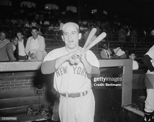 Yogi Berra of the Yankees is armed with three bats as he warmed up for another game against the Chicago White Sox. Previous night, the Chicagoans...