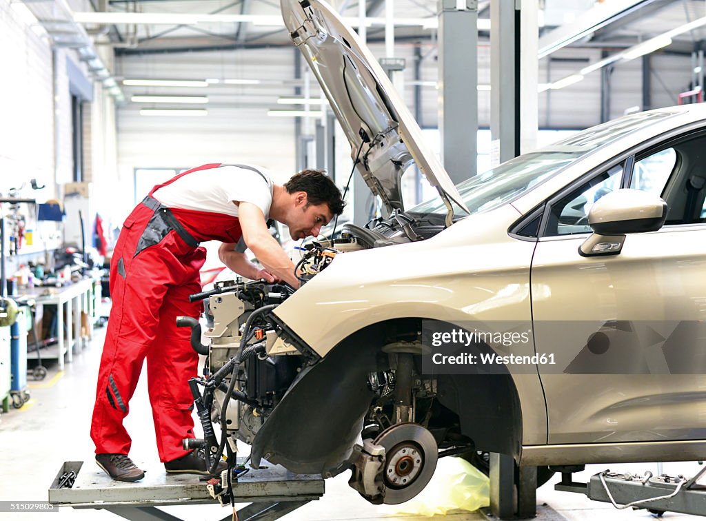 Car mechanic in a workshop working at car