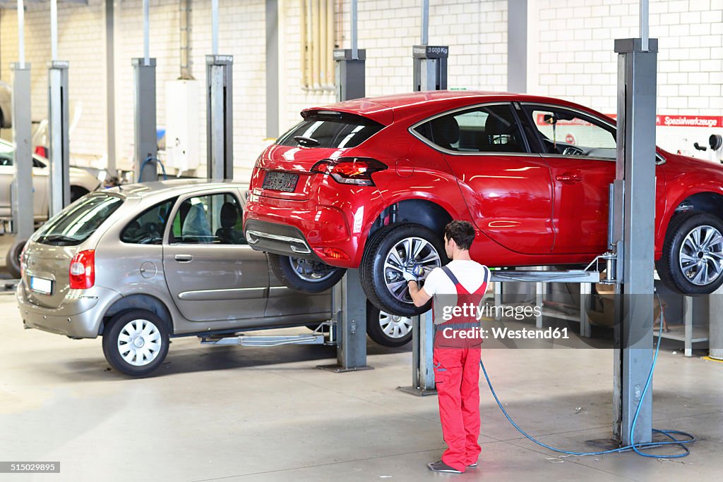Car mechanic in a workshop changing tires