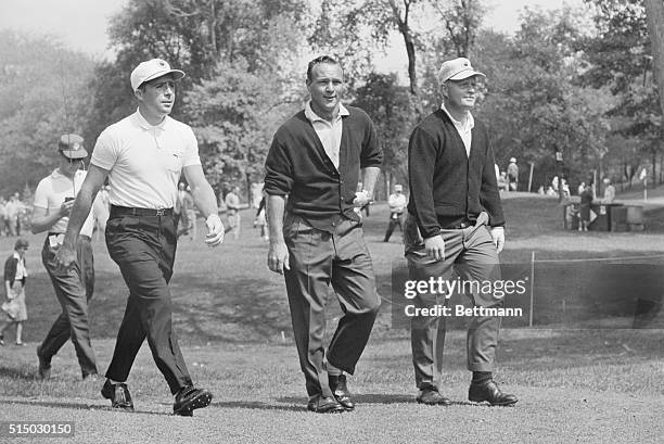 Professional golfers Gary Player, Arnold Palmer and Jack Nicklaus walking up a fairway in a practice round at the Firestone Country Club golf course...