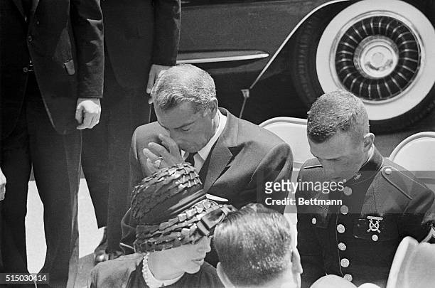 Joe DiMaggio puts his head in his hands and wipes his eyes in front of the mausoleum as the casket is taken from the horse to the stand in front of...
