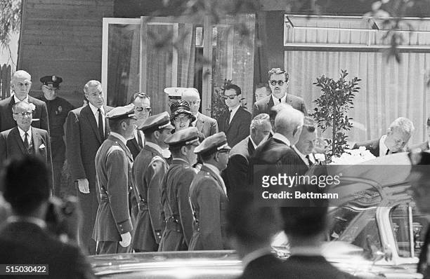 Marilyn Monroe's casket is carried out of the Westwood Park Chapel past a line of guards after the service. Mourners follow the casket. Joe DiMaggio,...