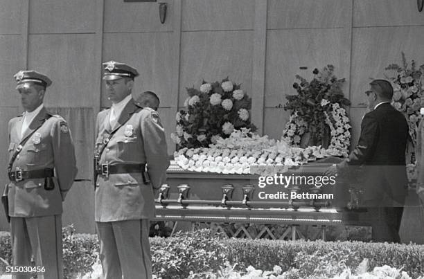 Pallbearers put casket into place on stand in front of the Mausoleum. Between guards at left on curtain covered crypt that will be the final resting...