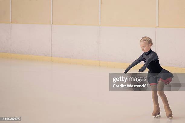 young female figure skater moving on ice rink - eiskunstlauf wettbewerb stock-fotos und bilder