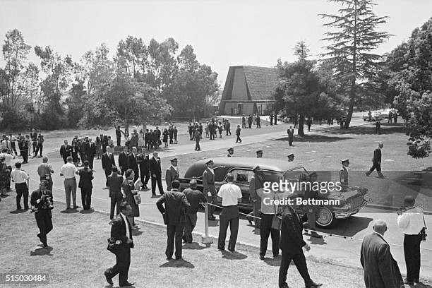 Mourners follow the hearse with movie star Marilyn Monroe's casket being taken from the chapel to its final resting place at Westwood Memorial Park,...