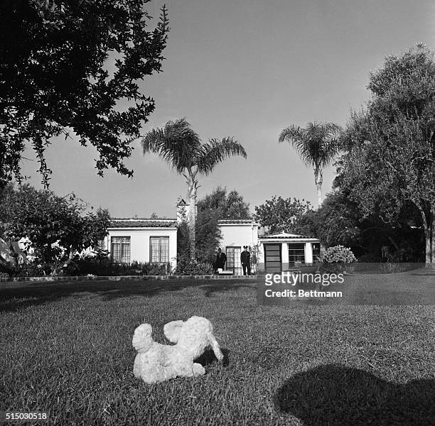 Police are shown in front of Marilyn Monroe's home after her apparent suicide from an overdose of barbiturates. Note the stuffed dog toys on the lawn.