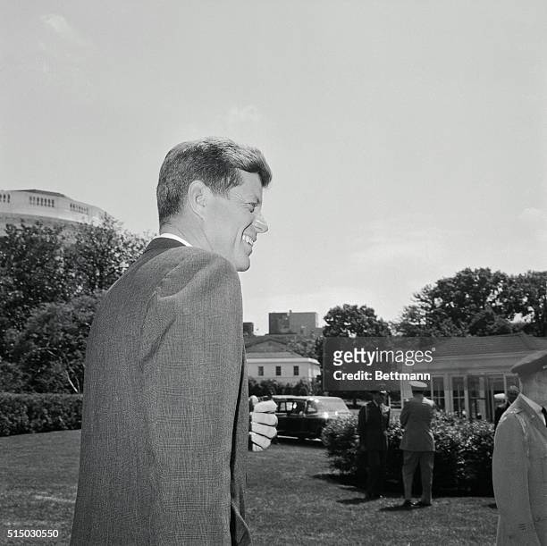 President Kennedy smiles as he leaves the White House today, his 45th birthday, to motor to the Pentagon as part of his continuing series of visits...