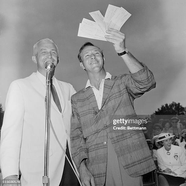 Arnold Palmer holds aloft 5 checks he received for winning the American Golf Classic at the Firestone Country Club on August 12th. The win enabled...