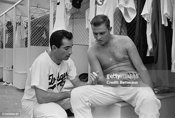 Sandy Koufax discusses his injured finger with fellow Dodger pitcher Don Drysdale shortly before game with San Francisco Giants 7/27. Sandy's doctor...