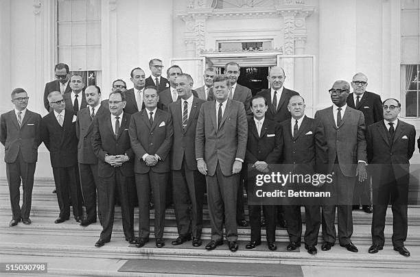 President Kennedy and Vice President Lyndon B. Johnson pose with a group of Latin American officials on the steps of the White House prior to a...