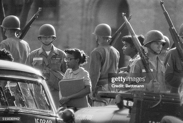 African-American students attending Little Rock Central High School are escorted to a waiting Army station wagon for their return home after classes,...