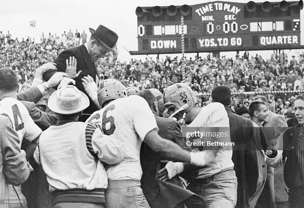 Victorious Notre Dame Football Players Carrying Coach