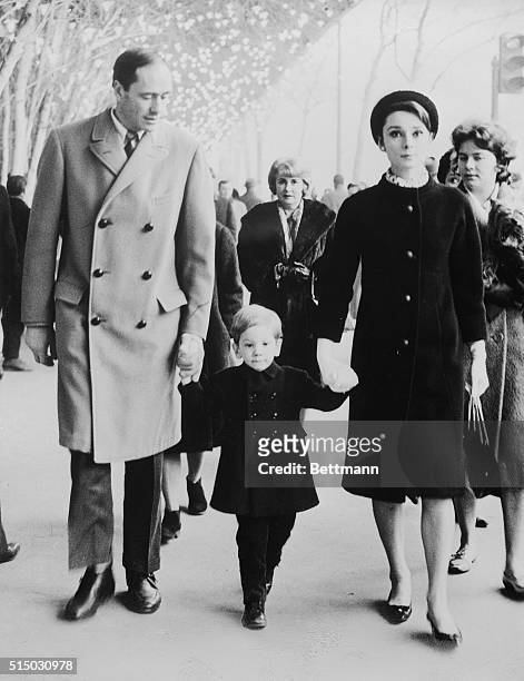 Making a handsome threesome on the streets of Paris are Mel Ferrer and Audrey Hepburn with their two year old son, Sean. The "movieland" family,...