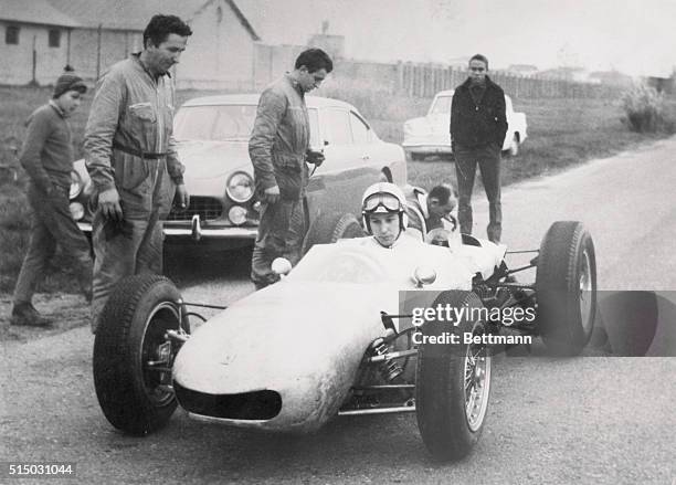 Modena, Italy: From Two To Four Wheels. A motorcycle ace now on four wheels, John Surtees of Britain who has recently taken to auto-racing, is seen...