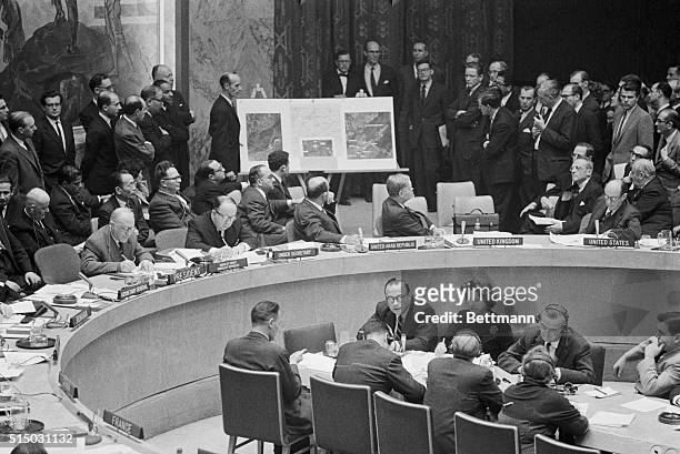 United Nations ambassador Adlai Stevenson and Soviet ambassador Valerian Zorin turn to look at display of aerial photos brought into the Security...