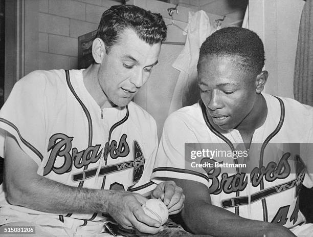 Nippy Jones, left, shows Hank Aaron the shoe polish on the ball that he was hit by, sending him to first and a dramatic finale to a Braves victory in...