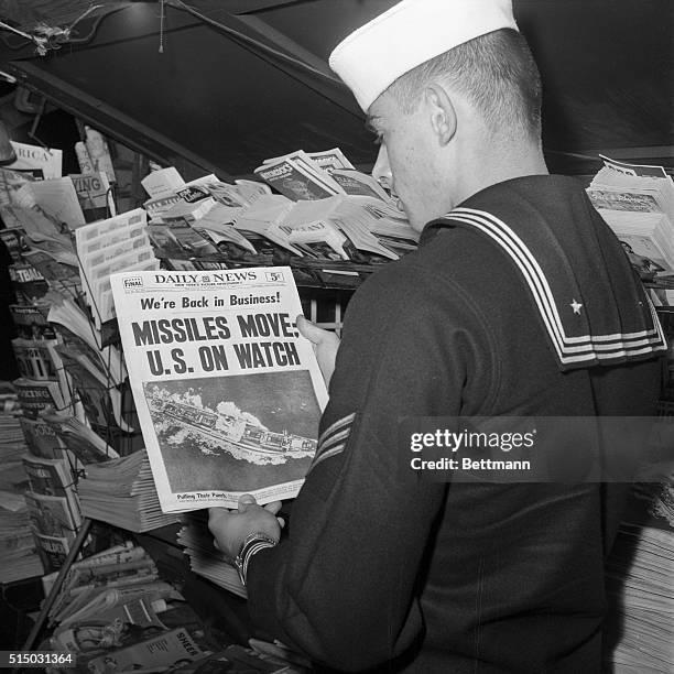 Gilbert Lund, U.S.N., of Chicago, Illinois, looks at the first copy of the New York Daily News at a newsstand after the eight-day strike against the...