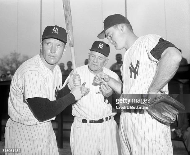 The Yankees' Mickey Mantle holds the bat at left while Yankee manager Casey Stengel gives a bit of grip advice to rookie sensation Deron Johnson at...