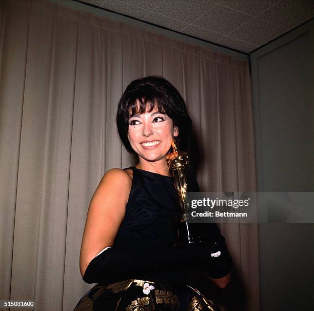 Actress Rita Moreno is shown here smiling as she holds her Academy Award.