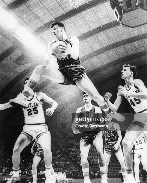 North Carolina's Bill Cunningham goes high between two Maryland players, Jerry Greenspan and Phil Carlson , to snare a rebound in Atlantic Coast...