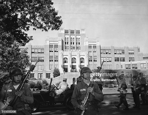 Federal troops stand guard in front of Central High School, in Little Rock, Arkansas, after Federal courts ordered the enforcement of desegregation...
