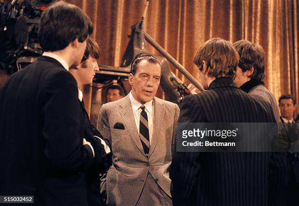 American television host Ed Sullivan talks, with the members of British rock group the Beatles, on the set of his television variety series, 'The Ed...