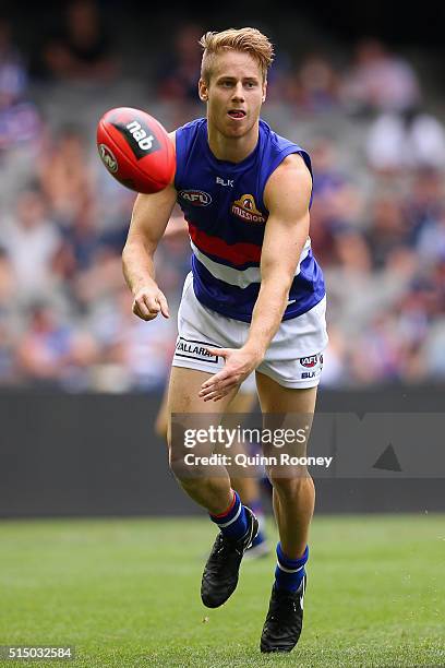 Lachie Hunter of the Bulldogs handballs during the 2016 NAB Challenge AFL match between the Collingwood Magpies and the Western Bulldogs at Etihad...