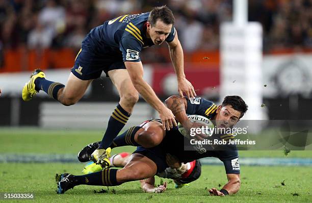 Rob Thompson of the Highlanders is taken to the ground while Ben Smith ranges up in support during the round three Super Rugby match between the...