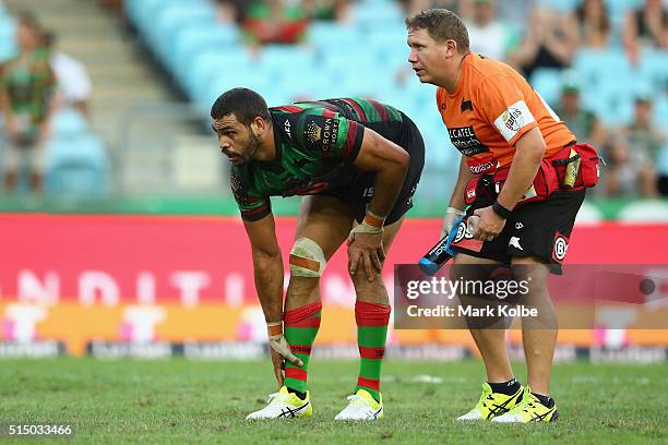 Greg Inglis of the Rabbitohs watches on as he receives attention from the trainer during the round two NRL match between the South Sydney Rabbitohs...