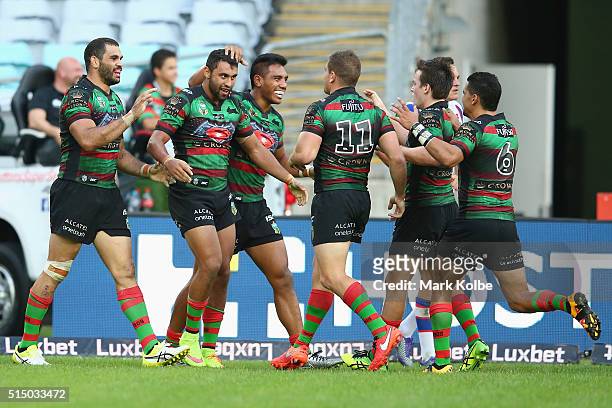 Alex Johnston of the Rabbitohs celebrates with his team mates after scoring a try during the round two NRL match between the South Sydney Rabbitohs...