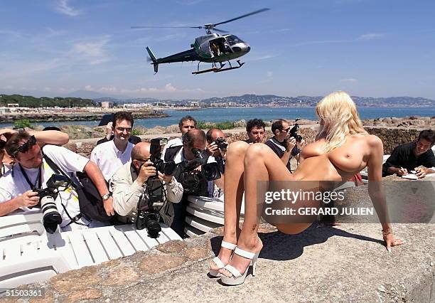 An adult movie actress, Eva, poses beside the Hot d'Or trophy 16 May 2000 in Cannes on the eve of the Hot d'Or ceremony where best actresses, actors,...