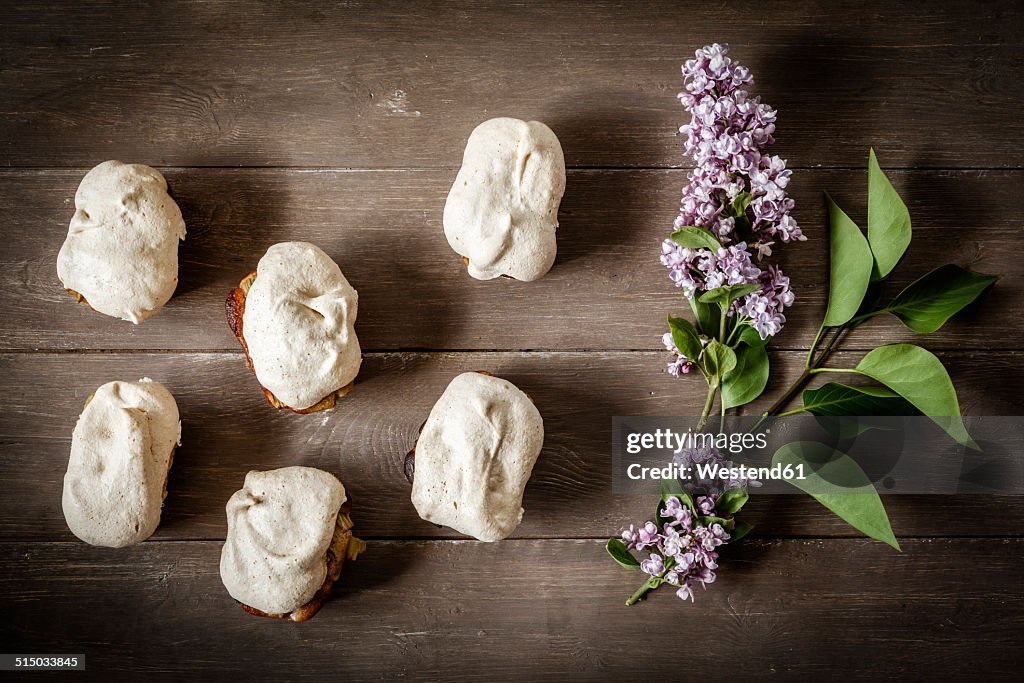 Gluten-free rhubarb cake with meringue and blossoms of lilac, elevated view