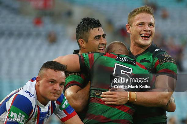 Jaelen Feeney of the Knights looks dejected as Bryson Goodwin of the Rabbitohs celebrates with his team mates Aaron Gray and George Burgess of the...