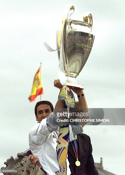 Real Madrid's player Raul Gonzalez Blanco holds the Champion's League Cup as he stands on the Cibeles Goddess statue with his teammates 25 May 2000,...