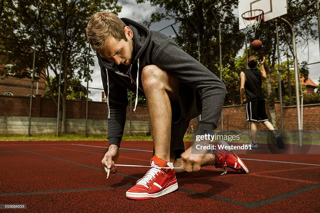 Young basketball player doing up the shoelaces