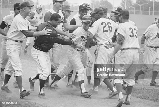 Phillies outfielder Johnny Callison is mobbed by his National League teammates after he hit a ninth inning home run to break the 4-4 tie in the...