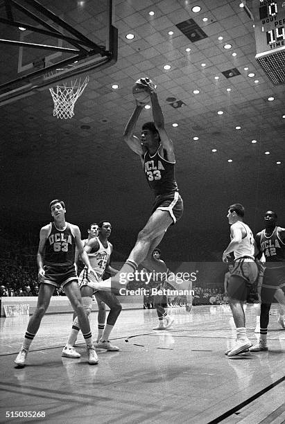 Louisville, KY- Lew Alcindor, UCLA No. 33, takes the ball away from the board on a rebound while teammate Lynn Shackleford, No. 53, looks on. The...