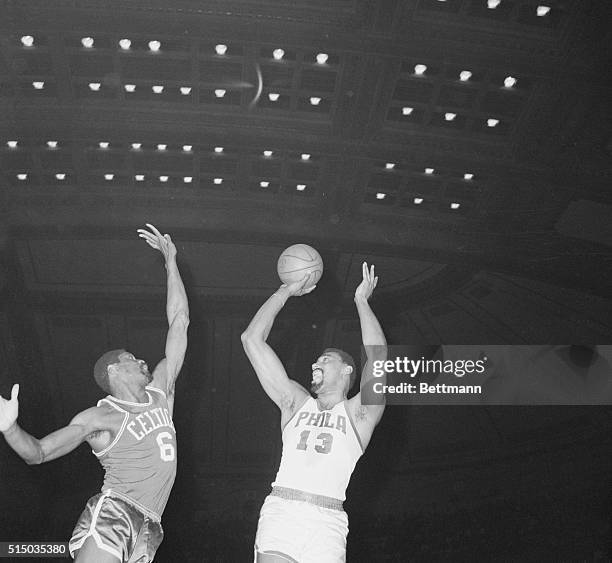 Boston, Massachusetts: Wilt Chamberlain, , Philadelphia 76ers, shoots fade-away-one-hander as Bill Russell, , attempts to block the shot.