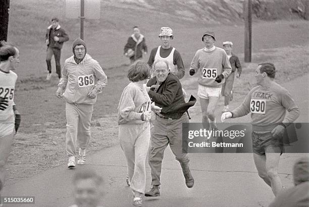 The rule that no women shall run in the Boston Athletic Association Marathon is being put to a very real test in this photo. Trainer Jack Semple...