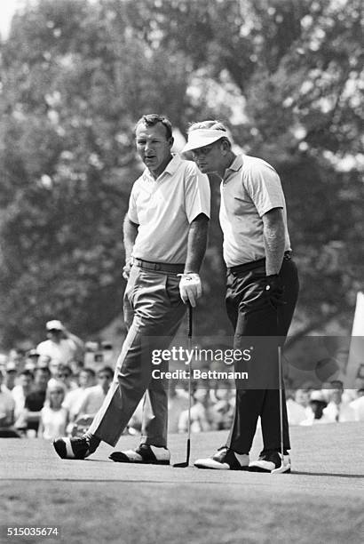 Arnold Palmer leans on his putter and waits as Jack Nicklaus lines up a putt on the second hole of the final round of the Westchester Golf Classic at...