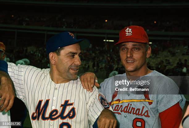 Roger Maris, St. Louis Cardinals outfielder stands with his arm on New York Mets coach, Yogi Berra's shoulder as they chat prior to start of game,...