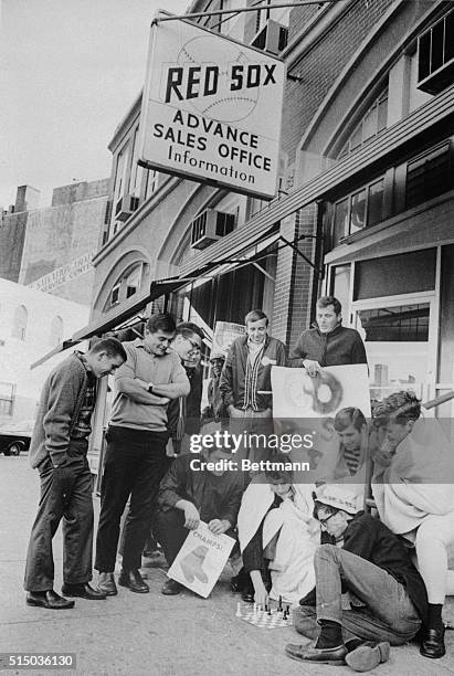 Boston: Baseball fans are shown wrapped in blankets and playing a game of chess while they wait in line, outside Fenway Park, to buy tickets to first...